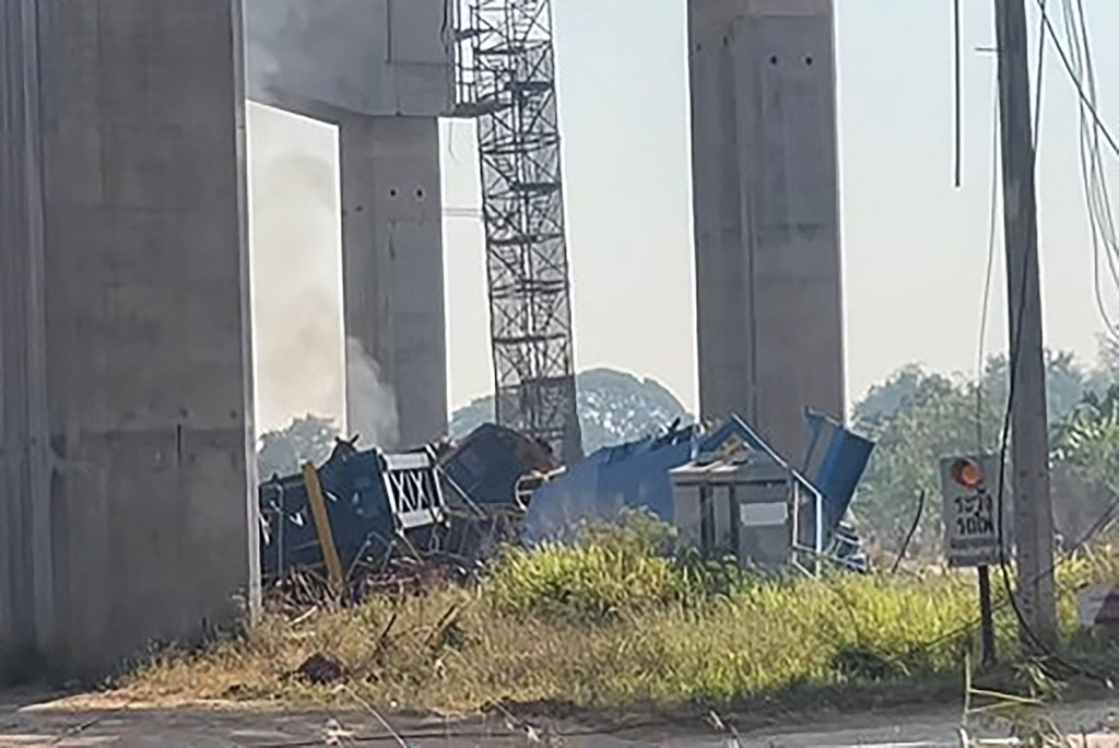 Photo by HANDOUT / COURTESY OF FACEBOOK USER SMITH MIKLE / AFP  This screen grab made from UGC handout video footage courtesy of Facebook user Smith Mikle taken and released on January 14, 2026 shows the wreckage of a train that crashed after a construction crane collapsed in Thailand's Nakhon Ratchasima province.