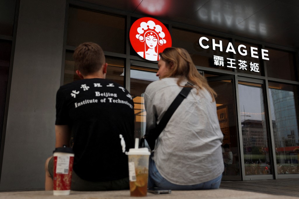 FILE PHOTO: People sit outside a store of Chinese tea chain Chagee at a shopping mall in Beijing, China July 31, 2025. REUTERS/Florence Lo/File Photo
