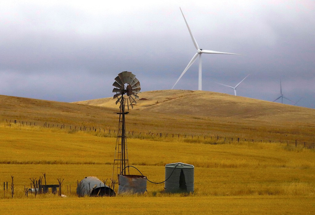 An old windmill stands in front of wind turbines in a paddock near the Hornsdale Power Reserve, featuring the world's largest lithium ion battery made by Tesla, located on the outskirts of the South Australian town of Jamestown, in Australia, December 1, 2017. REUTERS/David Gray/File Photo/File Photo
