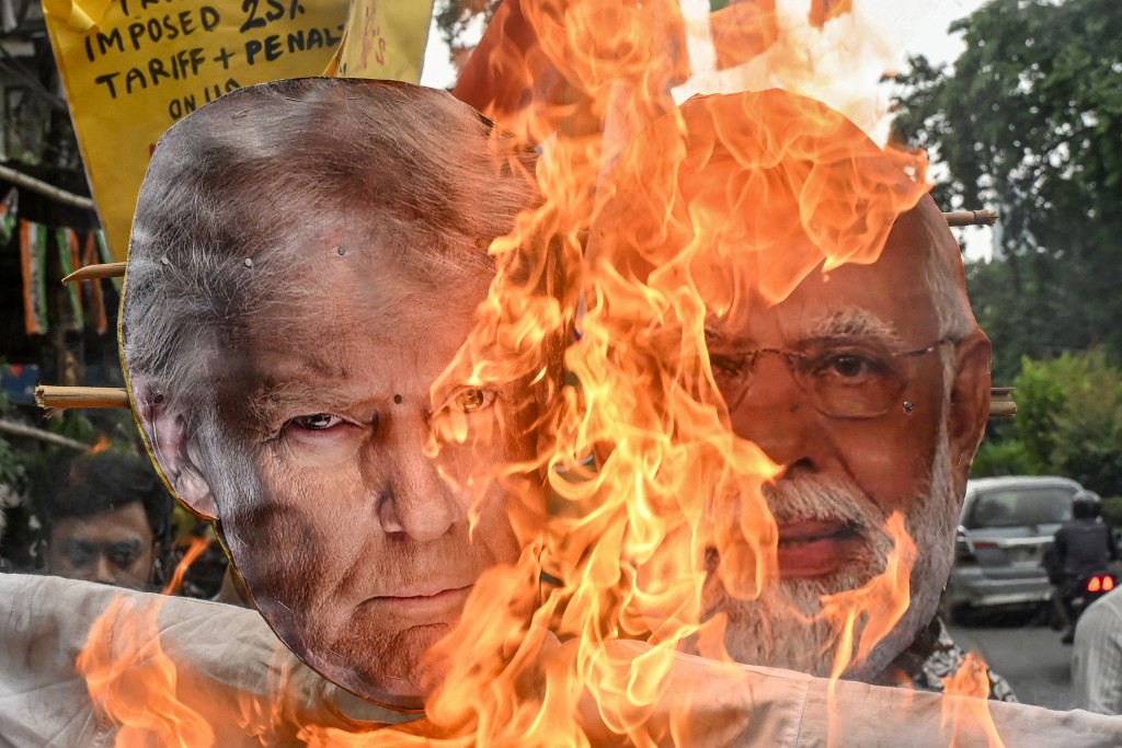 Congress activists burn an effigy of US President Donald Trump and Indian Prime Minister Narendra Modi as they protest against the Indo-US trade deal, after the former imposed 25 percent tariffs on Indian goods, during a demonstration in Kolkata on August 1, 2025. (AFP) 