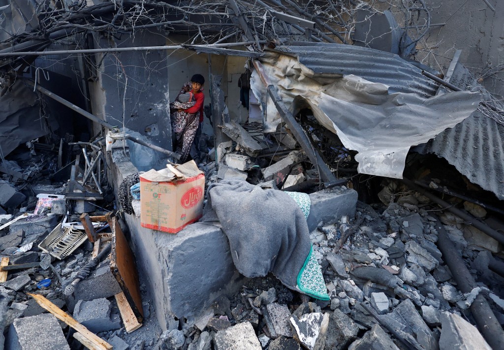 A Palestinian boy inspects the site of an overnight Israeli strike on a house, in Nuseirat, central Gaza Strip, October 29, 2025. REUTERS/Mahmoud Issa
