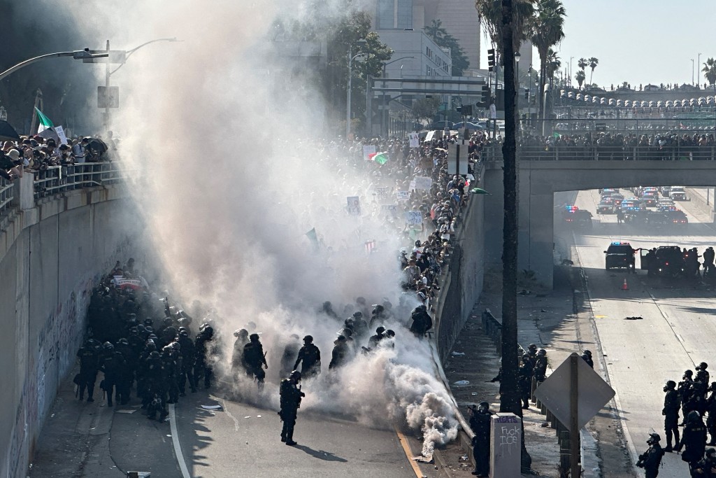 Police officers are enveloped in a cloud of smoke from tear gas and percussion grenades while guarding a highway onramp during a protest against federal immigration sweeps in downtown Los Angeles, California, U.S. June 8, 2025. (Reuters)