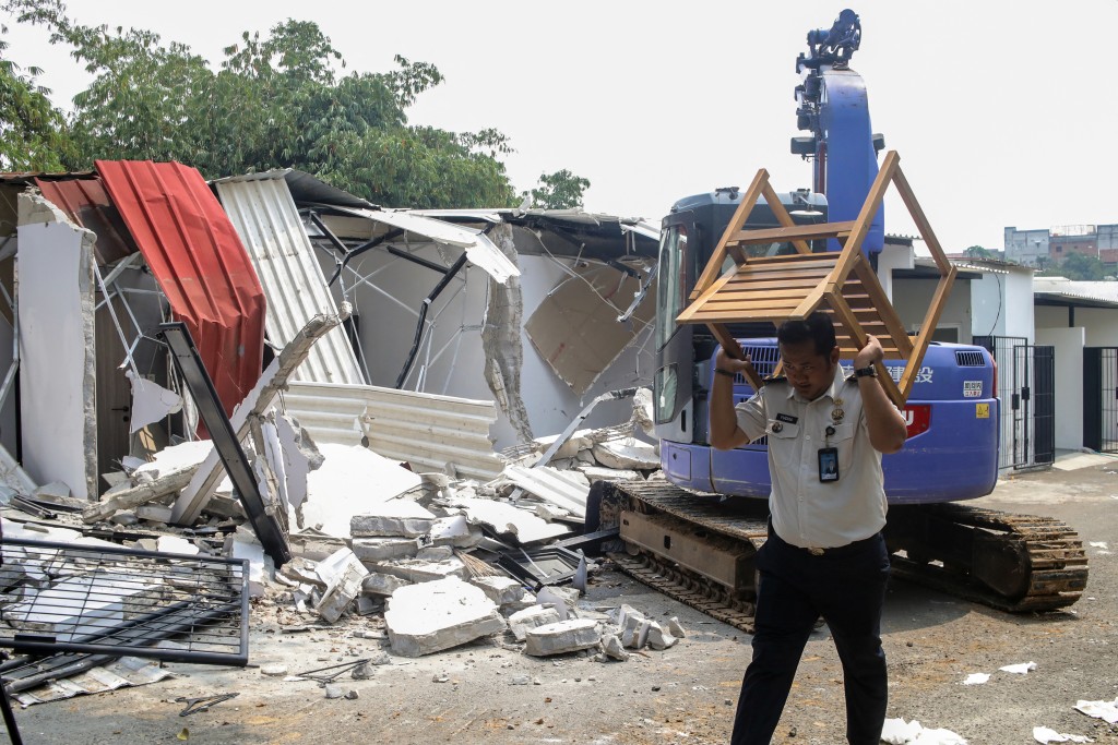 Photo by ABIMANYU / AFP  An official carries away furniture from one of the "villas" in the Cibinong men's prison, where inmates allegedly paid rent for the luxury accommodation, during the demolition of the structures on the prison grounds in Bogor on September 30, 2026.