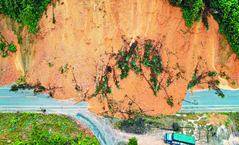 A truck driver braves a dangerous run around a landslide-hit road section in southern Guangxi. A truck driver braves a dangerous run around a landslide-hit road section in southern Guangxi.