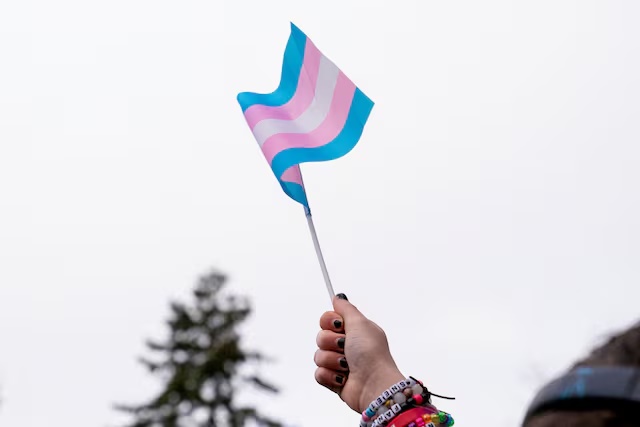 A demonstrator holds a trans flag during a rally in support of trans youth at Seattle Children’s hospital, following U.S. President Donald Trump’s executive order that denies federal funding for pediatric gender-affirming care, in Seattle, Washington, U.S. February 8, 2025. REUTERS/David Ryder/File Photo 