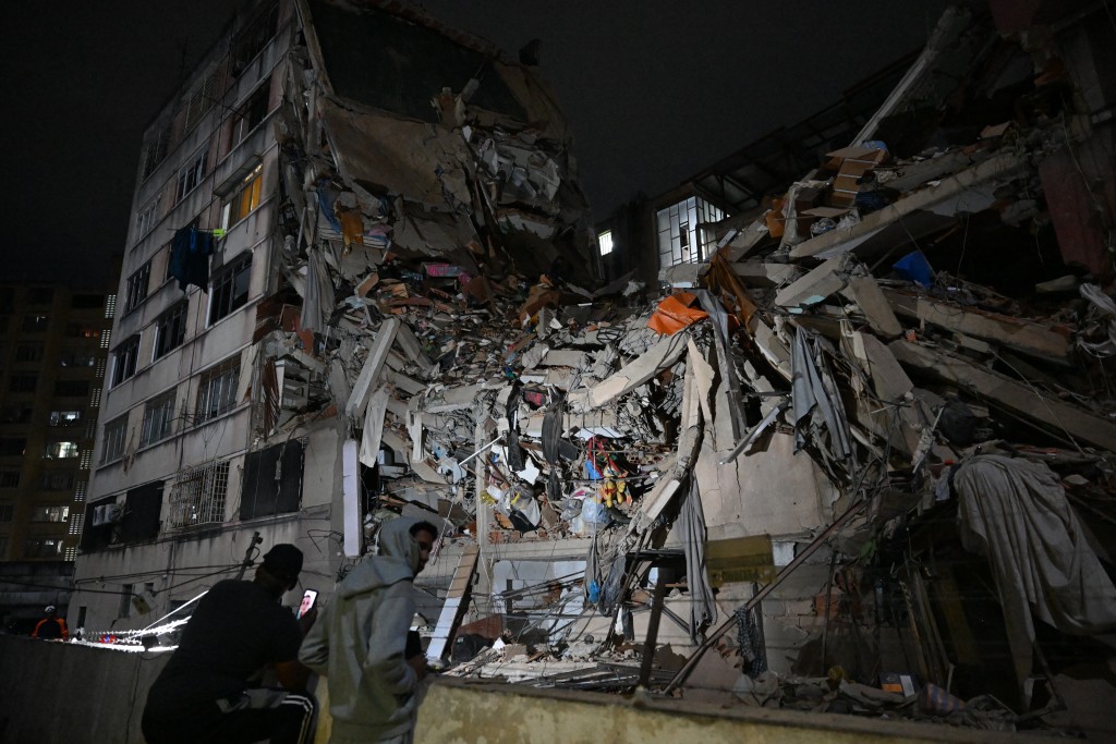 Photo by FEDERICO PARRA / AFP  People look at a collapsed building in the Altamira neighbourhood following an earthquake in Caracas on June 24, 2026.