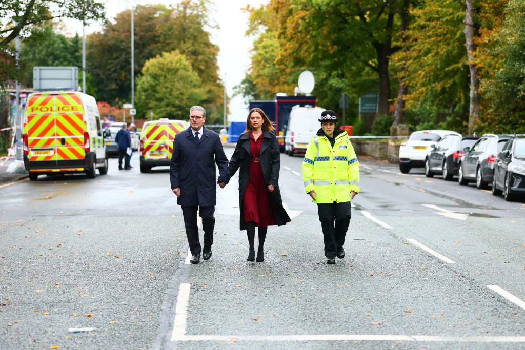 Britain's Prime Minister Keir Starmer and his wife Victoria react as they visit the scene outside Heaton Park Hebrew Congregation synagogue in Crumpsall, north Manchester, on October 3, 2025, following an attack at the synagogue yesterday. An attacker, named as Jihad al-Shamie, ploughed a car into a crowd outside a packed synagogue in Britain on Thursday, a Jewish holiday, before going on a stabbing spree, killing two people and leaving three wounded, police said. (Photo by Paul Currie / AFP)