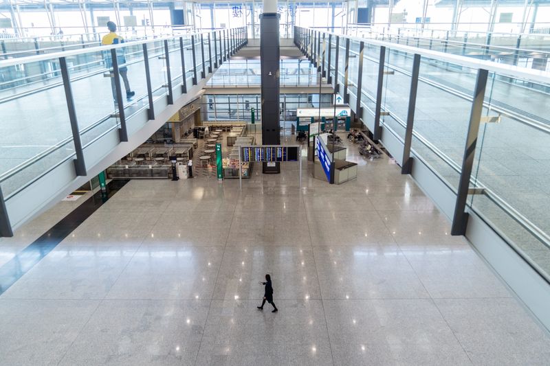 A staff member walks through the arrivals hall at Hong Kong International Airport on Nov. 29. (Chan Long Hei/Bloomberg) A staff member walks through the arrivals hall at Hong Kong International Airport on Nov. 29. (Chan Long Hei/Bloomberg)