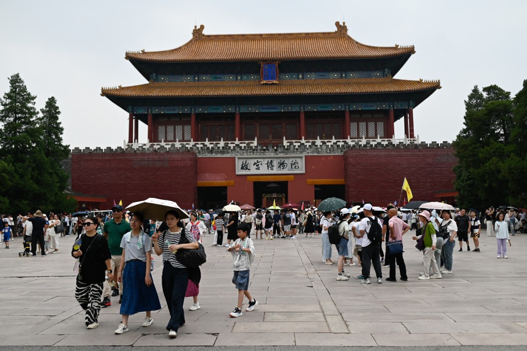 Tourists walk outside the Forbiden City in Beijing on July 11, 2025. (Photo by WANG Zhao / AFP)