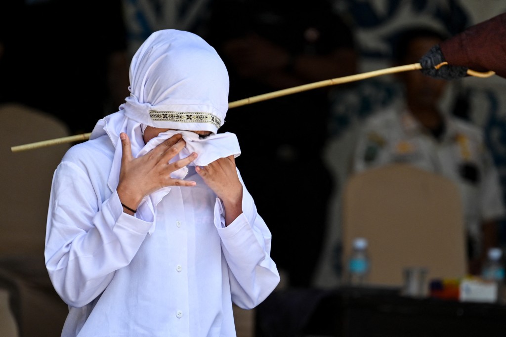  A woman reacts while being publicly caned by a member of the Sharia police in Banda Aceh on January 29, 2026. (Photo by CHAIDEER MAHYUDDIN / AFP)