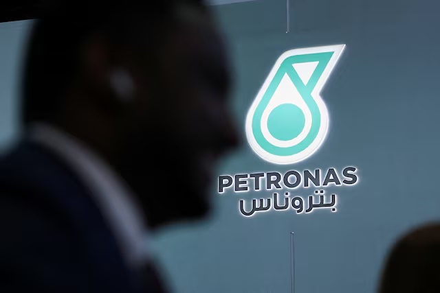 A man walks past a logo of PETRONAS during the annual energy industry event Abu Dhabi International Petroleum Exhibition and Conference (ADIPEC) in Abu Dhabi, United Arab Emirates, November 3, 2025. REUTERS/Amr Alfiky