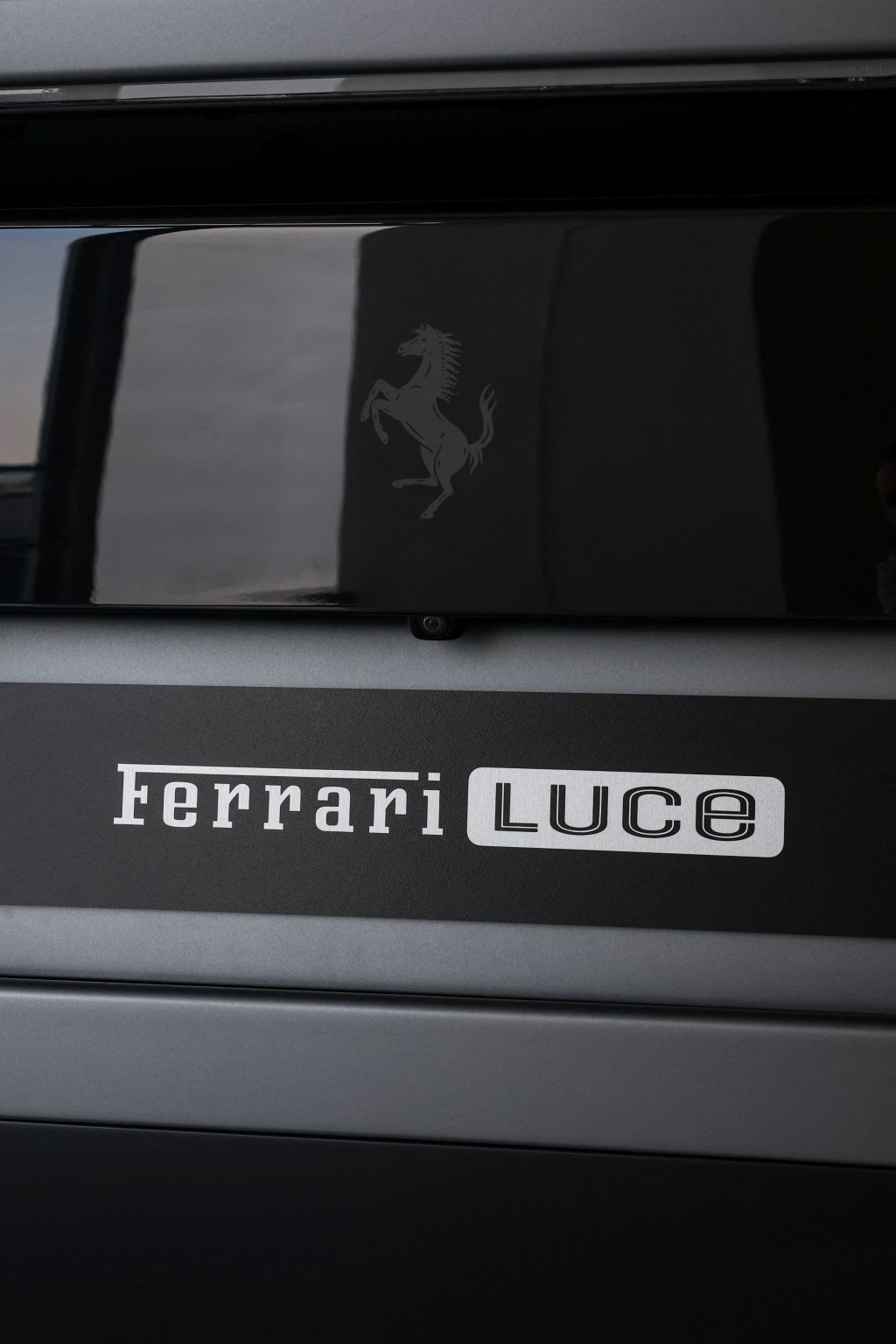 The Ferrari Luce nameplate and prancing horse emblem sit on the rear of the electric car in Maranello, Italy, July 27, 2026. REUTERS/Claudia Greco