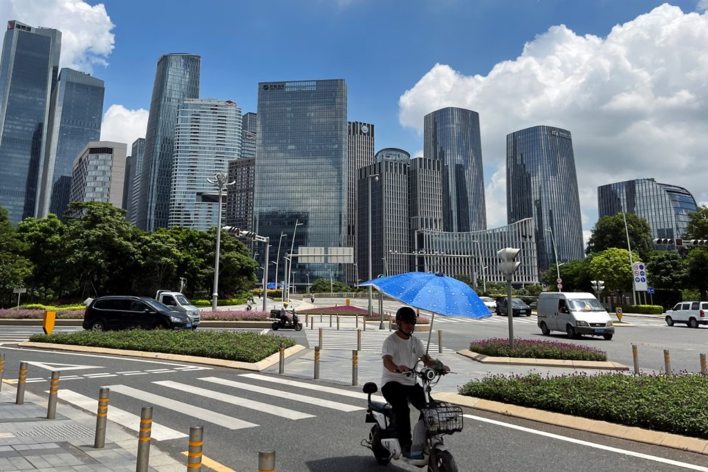 A man rides a scooter past a completed central area of Qianhai new district in Shenzhen, Guangdong province, China August 25, 2023. REUTERS