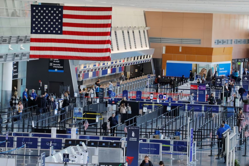 Travellers make their way through a TSA security checkpoint, as airlines cancelled flights at 40 major airports after the government imposed an unprecedented cut to air travel, citing air traffic control safety concerns because of a record-setting government shutdown, at Logan International Airport in Boston, Massachusetts, U.S., November 7, 2025. REUTERS/Brian Snyder