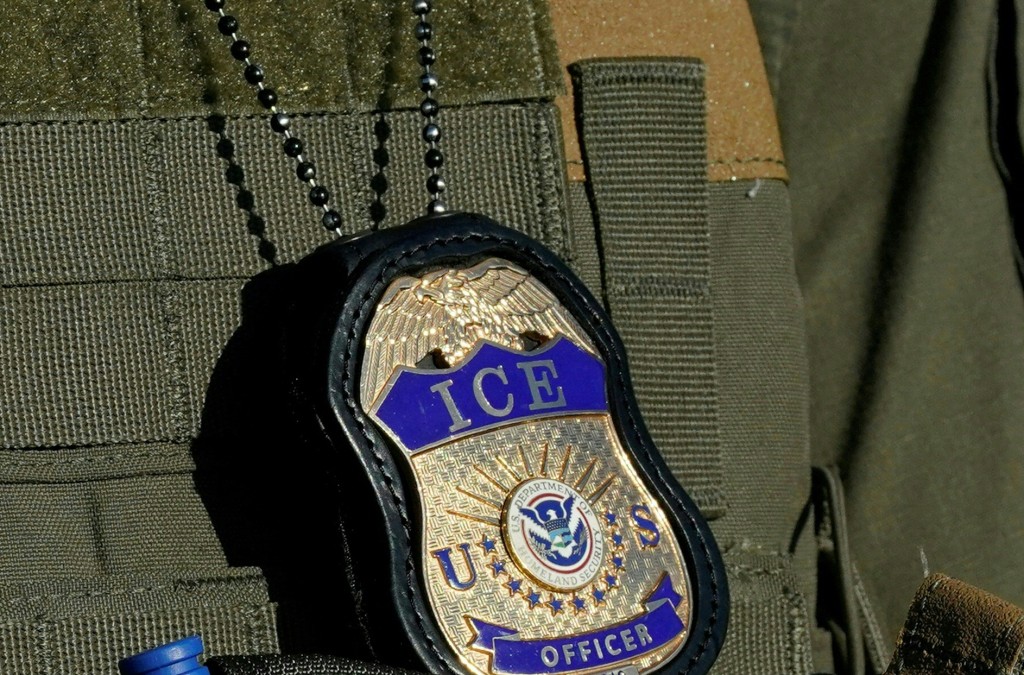 File image dated May 7, 2025 in Newark, New Jersey, shows a badge hanging over the uniform of an Immigration and Customs Enforcement (ICE) agent.  (Photo by TIMOTHY A. CLARY / AFP)