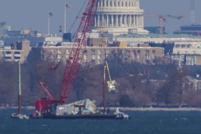 Crews work to retrieve the wreckage of American Eagle flight 5342 in the Potomac River, in the aftermath of the collision of American Eagle flight 5342 and a Black Hawk helicopter that crashed into the river, with the Capitol dome in the background, as seen from Virginia, U.S., February 4, 2025.REUTERS/Nathan Howard/File Photo 