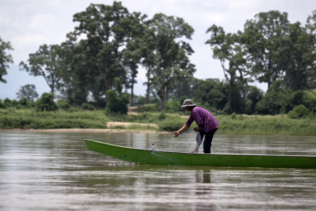 Photo by LILLIAN SUWANRUMPHA / AFP This photo taken on June 4, 2026 shows a man fishing near the confluence of the Kok River and Mekong River in Chiang Saen, northern Thailand’s Chiang Rai province.