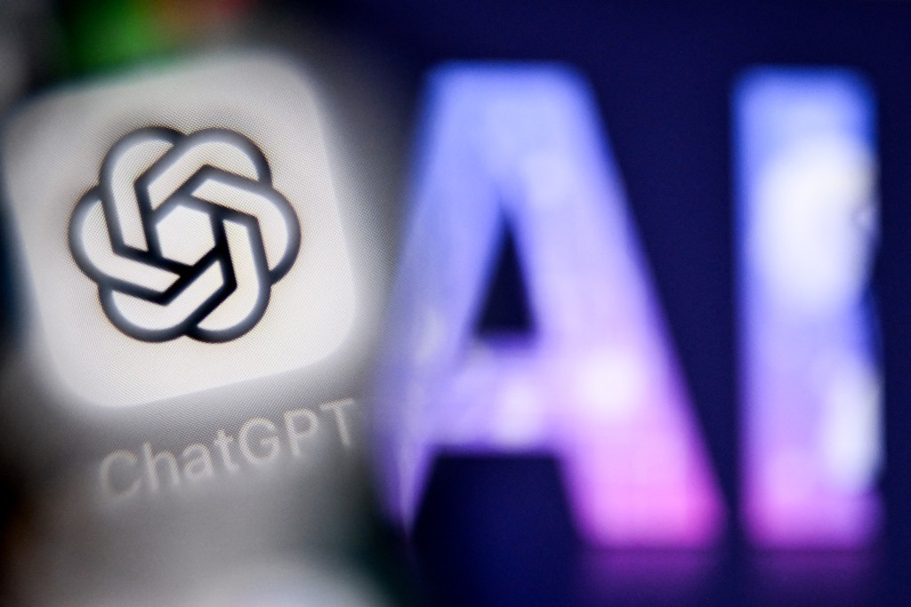 A photo taken on September 1, 2025 shows the letters AI for Artificial Intelligence on a laptop screen (R) next to the logo of the ChatGPT application on a smartphone screen in Frankfurt am Main, western Germany.  (Photo by Kirill KUDRYAVTSEV / AFP)