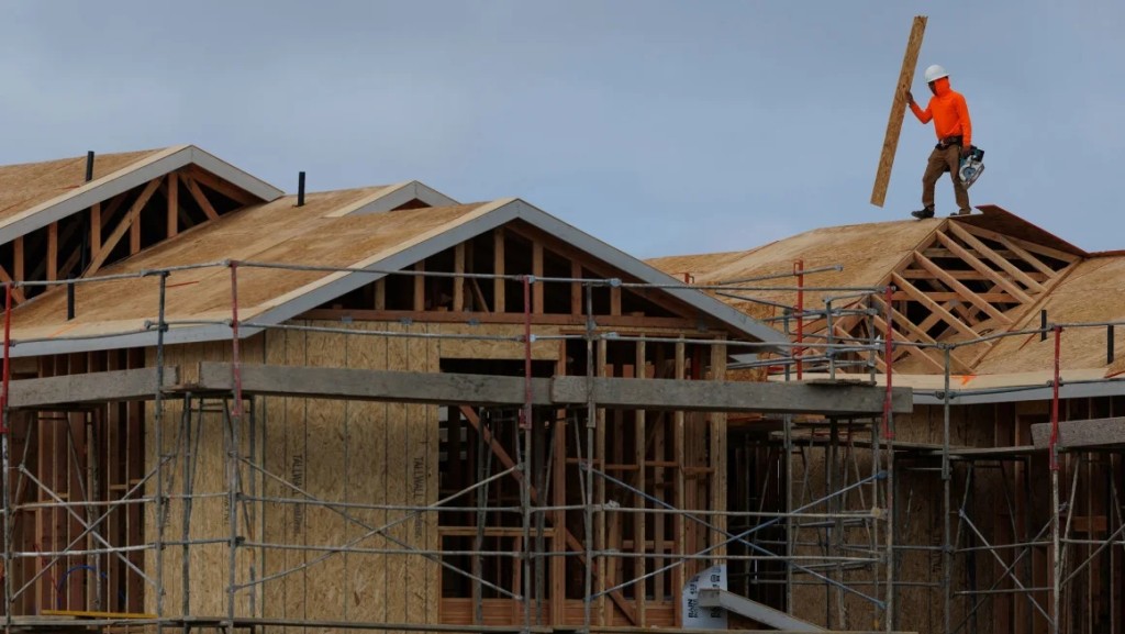 A construction worker helps builds a roof on a residential homes in Irvine, California, on March 28. Mike Blake/Reuters