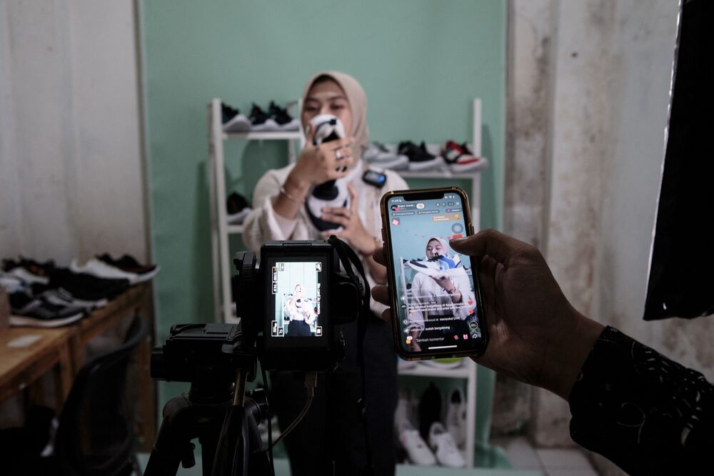 A staff of a small shoe manufacturer shows their new products to make an introductory video to be posted on social media in Bogor, West Java. (AFP) A staff of a small shoe manufacturer shows their new products to make an introductory video to be posted on social media in Bogor, West Java. (AFP)