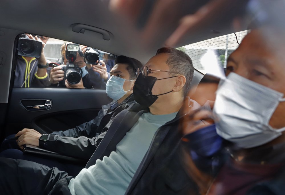 Former law professor Benny Tai, center, a key figure in Hong Kong's 2014 Occupy Central protests and also was one of the main organizers of the primaries, sits in a car after being arrested by police today. 