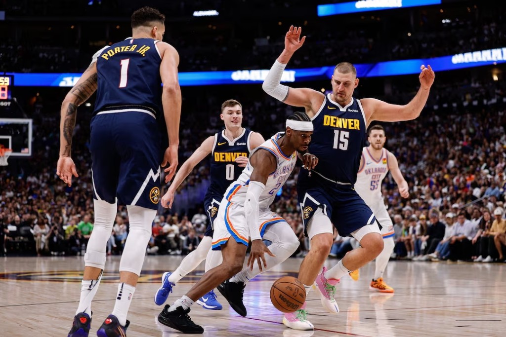 Oklahoma City Thunder guard Shai Gilgeous-Alexander (2) controls the ball against Denver Nuggets center Nikola Jokic (15) and guard Christian Braun (0) and forward Michael Porter Jr. (1) in the first quarter during game four. (Reuters)