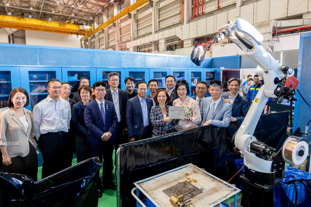 Legislators watch a welding robot demonstration to learn how the robot completes welding tasks quickly and precisely. They also pose for a photo holding a metal plate welded with the LegCo emblem. Legislators watch a welding robot demonstration to learn how the robot completes welding tasks quickly and precisely. They also pose for a photo holding a metal plate welded with the LegCo emblem.