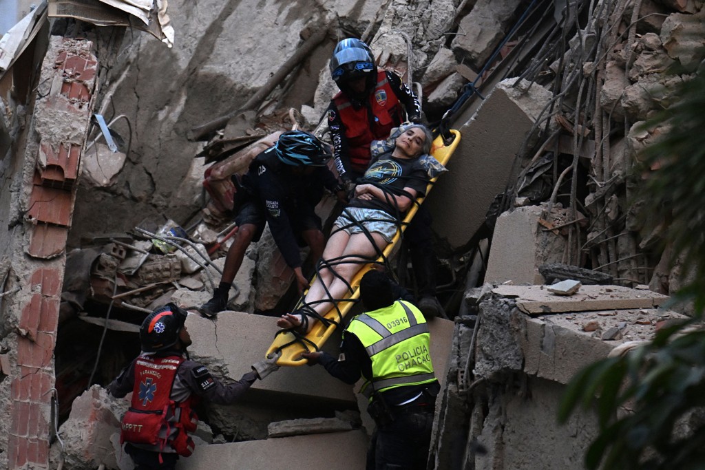 Photo by JUAN BARRETO / AFP  Rescue workers carry a person on a stretcher out of a collapsed building following an earthquake in Caracas on June 24, 2026.