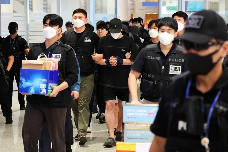 Police officers escort South Korean deportees suspected of being involved in online scam operations in Cambodia upon their arrival at the Incheon International Airport in Incheon, South Korea, October 18, 2025. REUTERS/Kim Hong-Ji