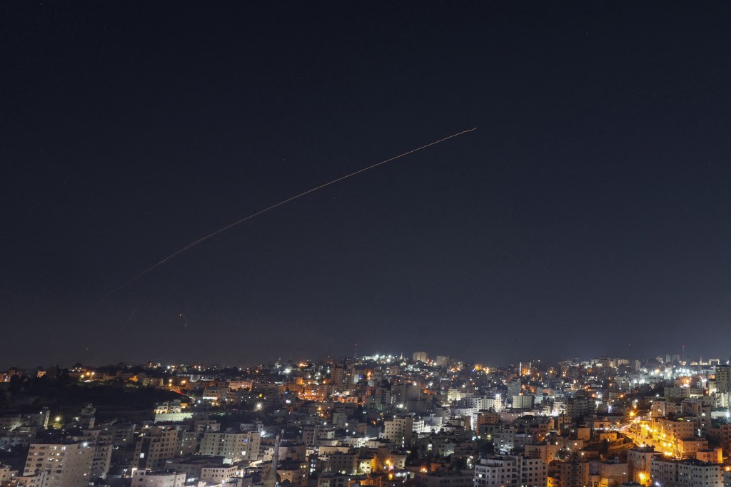 Rocket trails are seen in the sky above the city of Hebron, in the Israeli-occupied West Bank, amid a fresh barrage of Iranian missile attacks on March 4, 2026. (AFP)