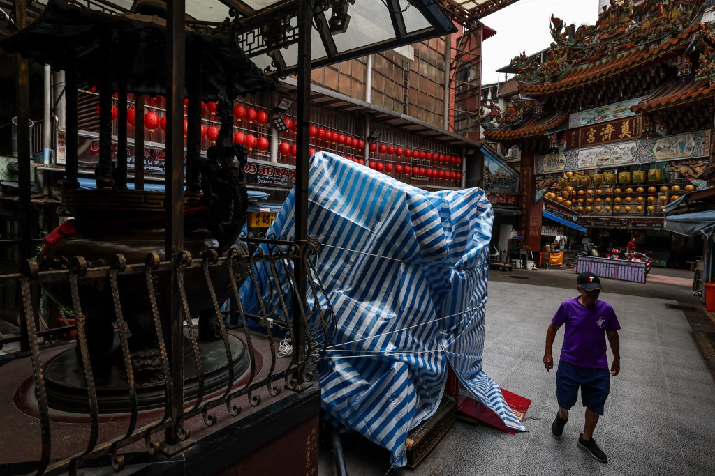 Statues outside Keelung's Dianji Temple are covered with protective tarpaulins ahead of the arrival of Typhoon Bavi in Keelung on July 10, 2026 (Photo by I-Hwa Cheng / AFP)