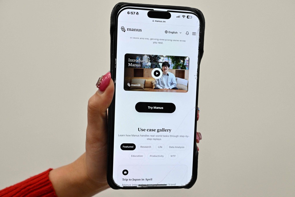 A photo illustration taken in Beijing on March 11, 2025 shows a mobile phone displaying an introduction screen for the AI assistant tool Manus, released by Chinese startup Butterfly Effect. (Photo by ADEK BERRY / AFP)