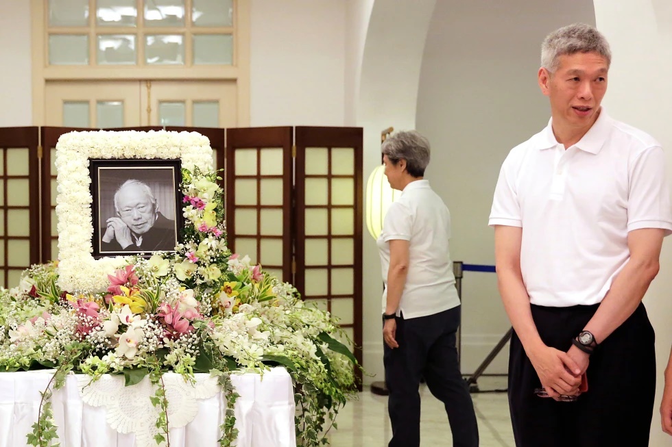 In this March 24, 2015, file photo, Prime Minister Lee Hsien Loong’s brother, Lee Hsien Yang, right, receives friends and family members paying their respects to the late Lee Kuan Yew during a private family wake at the Istana or Presidential Palace in Singapore. (AP Photo/Wong Maye-E, File)