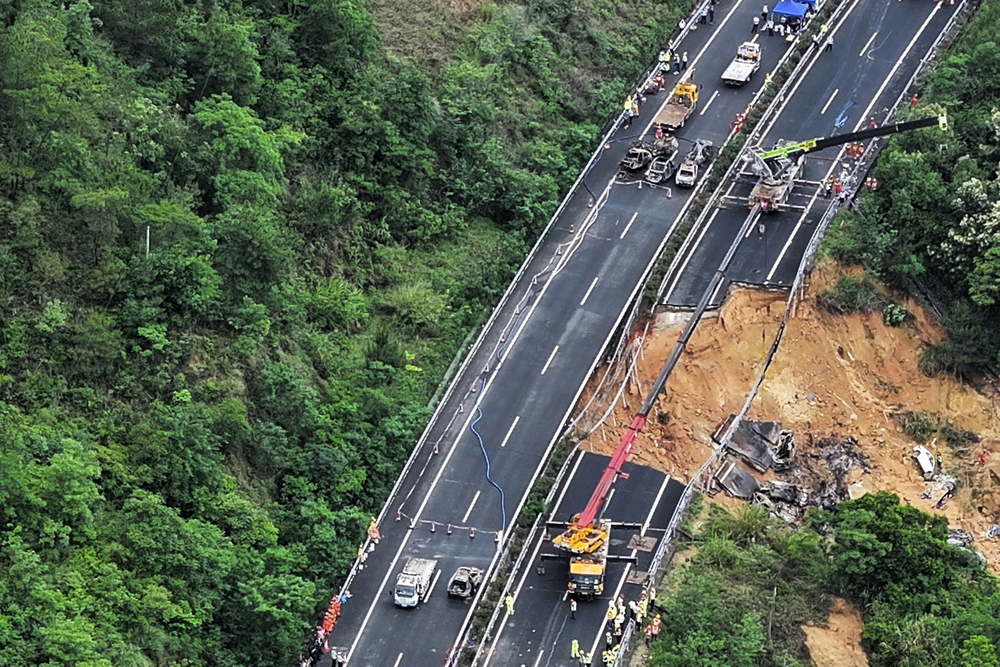 Rescuers work at the site of a collapsed road section of the Meizhou-Dabu Expressway, with wrecked vehicles lying in a deep muddy pit. Rescuers work at the site of a collapsed road section of the Meizhou-Dabu Expressway, with wrecked vehicles lying in a deep muddy pit.