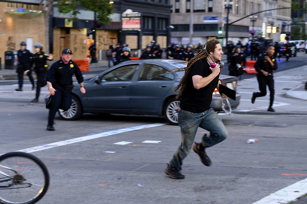 A man runs from police officers in Oakland, California,  Monday, June 1.