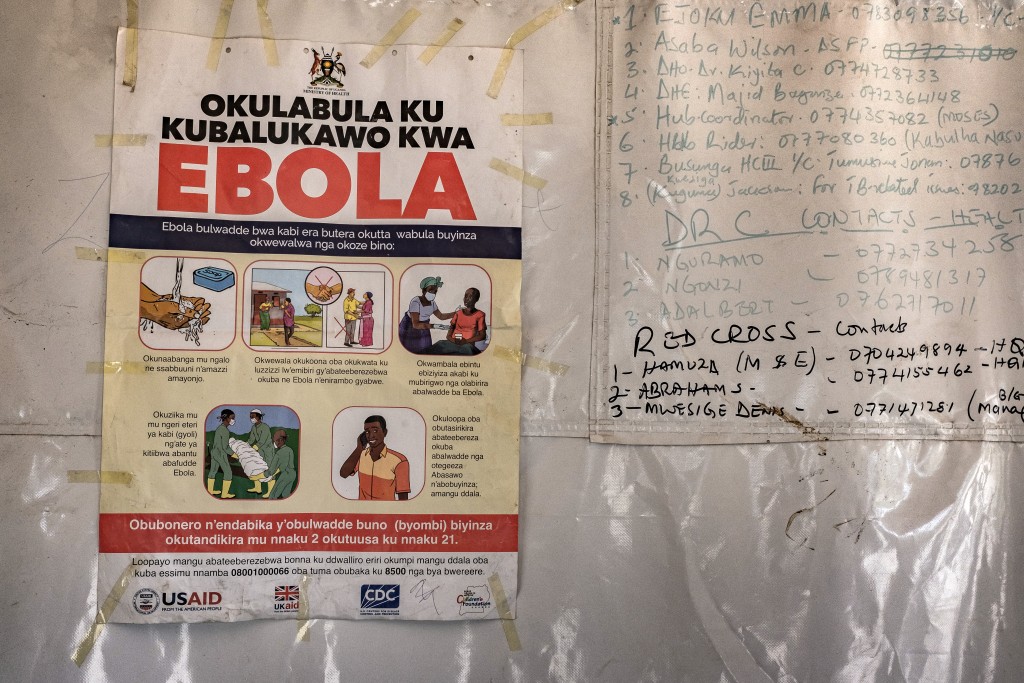 Photo by BADRU KATUMBA / AFP  A poster displaying Ebola emergency contact numbers is pinned to a tent at the Busunga border crossing between Uganda and the Democratic Republic of Congo in Bundibugyo, on May 18, 2026.