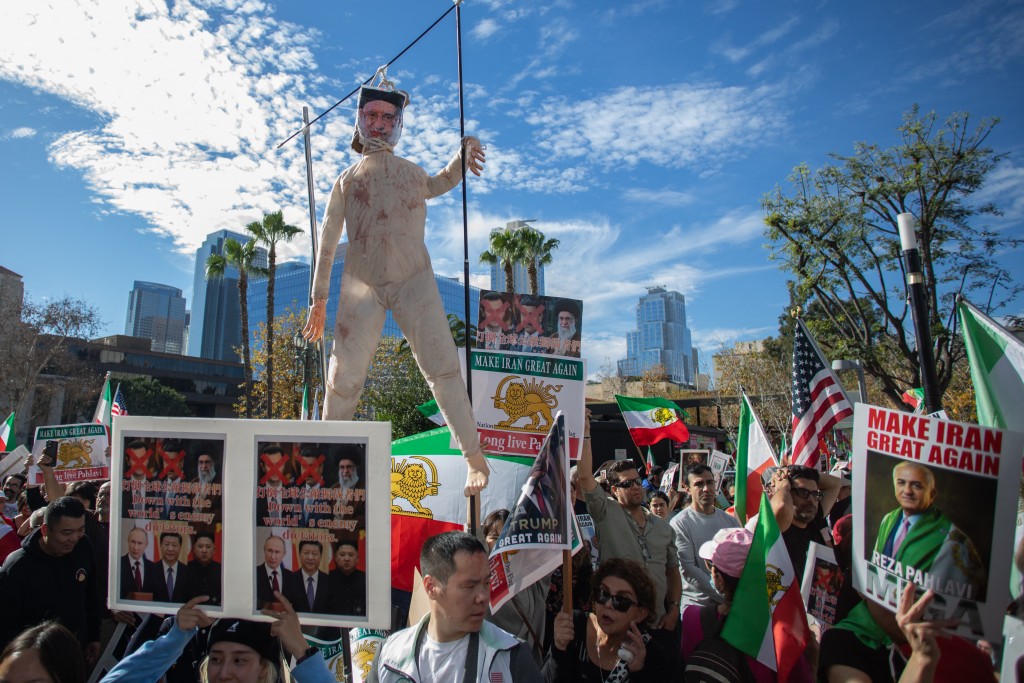 Members of the Iranian community and supporters hold a doll representing the Iranin Spreme Leader Ali Khamenei on a gallow while other hold signs and pre-regime Iranian flags during a "Solidarity with the People of Iran" event in front of City Hall in Downtown on January 18, 2026 in Los Angeles, California. (AFP)