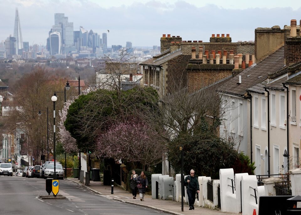 People walk along a residential street with the financial district in the distance in South London, Britain, February 26, 2024. REUTERS/Hannah McKay/File Photo People walk along a residential street with the financial district in the distance in South London, Britain, February 26, 2024. REUTERS/Hannah McKay/File Photo