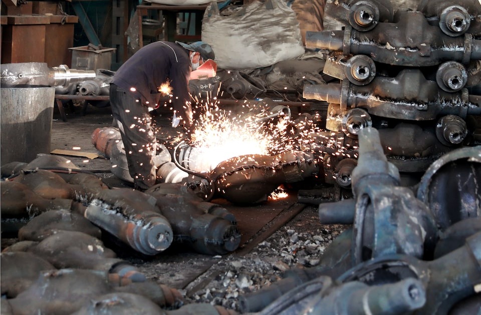 A worker welds automobile parts at a workshop manufacturing automobile accessories in Huaibei, Anhui. (Reuters) A worker welds automobile parts at a workshop manufacturing automobile accessories in Huaibei, Anhui. (Reuters)