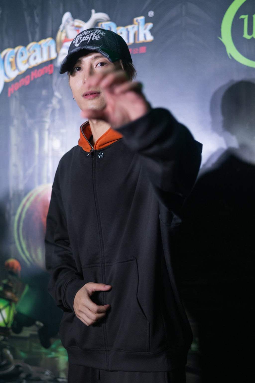 Jackson Wang flashes a heart gesture to reporters.