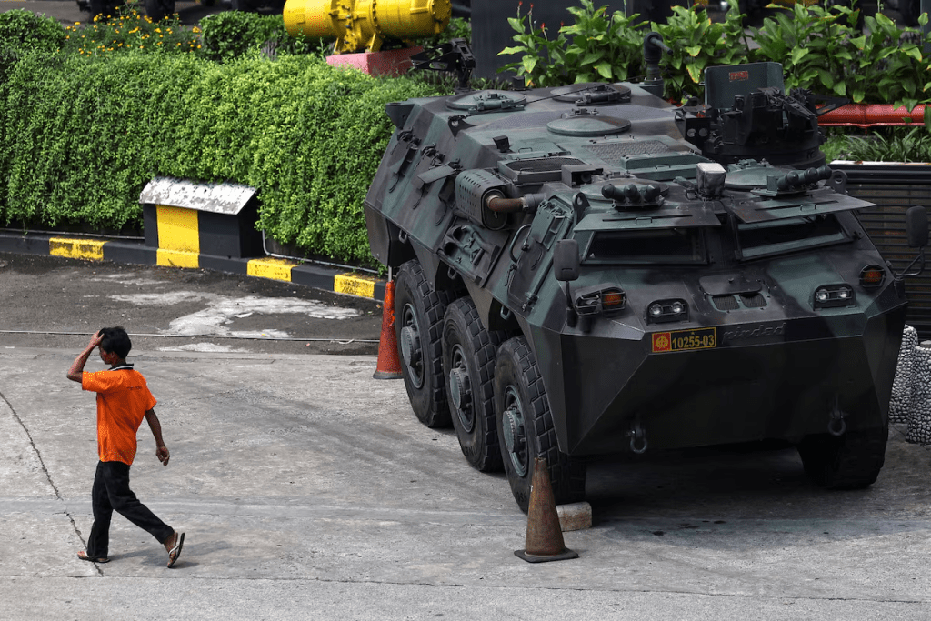 A man walks past an armoured military vehicle parked outside a shopping mall, amid the widespread anti-government protests and rioting over issues such as extra pay for parliamentarians and housing allowances that resulted in riots, in Jakarta, Indonesia, September 1, 2025. REUTERS/Willy Kurniawan 