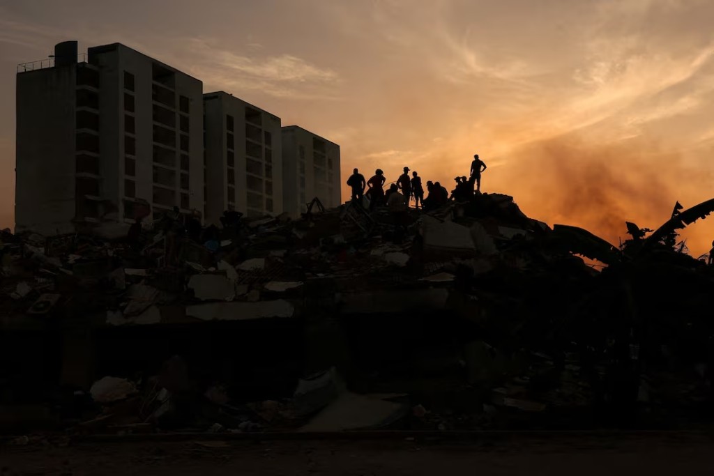 People stand on the rubble of a collapsed building, in the aftermath of earthquakes in La Guaira, Venezuela, June 25, 2026. REUTERS/Gaby Oraa 