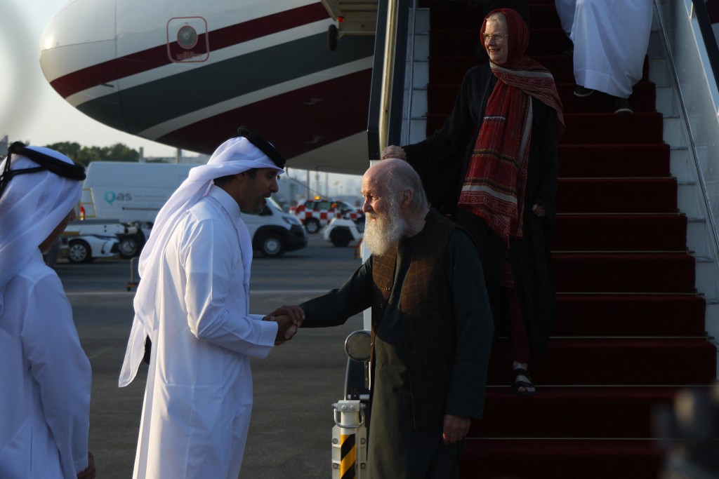 A Qatari officials welcomes Peter Reynolds and his wife Barbie after landing at the airport in Doha on September 19, 2025. Peter and Barbie Reynolds have been freed in Afghanistan after several months in detention following mediation by Qatar, an official with knowledge of the release told AFP on Friday. Taliban authorities in Kabul have confirmed the release. (Photo by Karim JAAFAR / AFP)