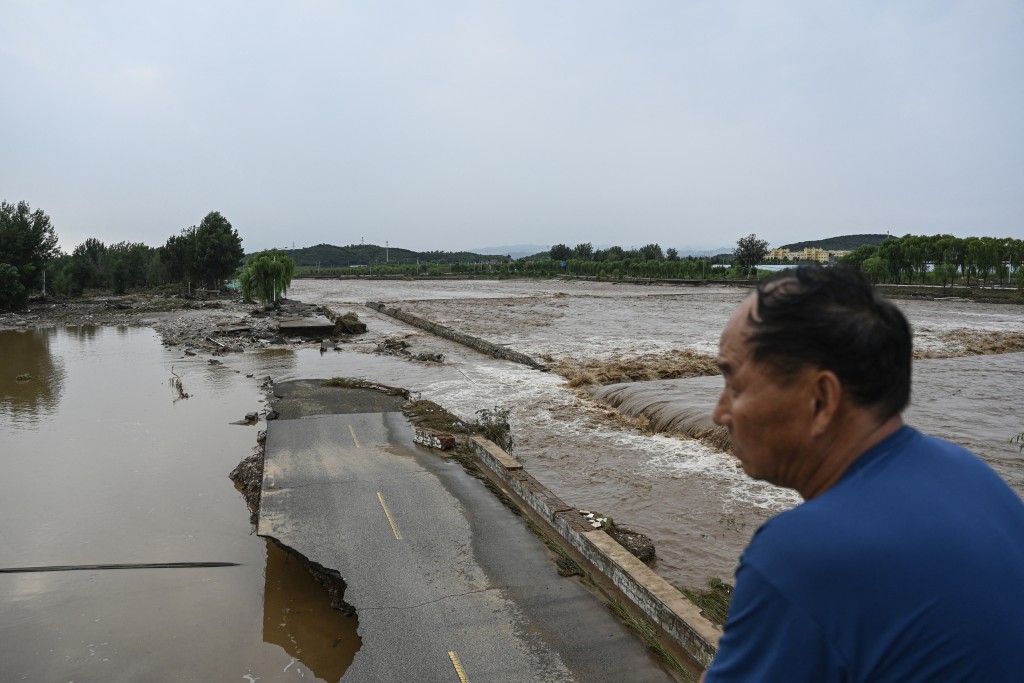 A damaged road is seen at a flooded area after heavy rains at Taishitun village in Miyun district, on the outskirts of Beijing on July 28, 2025. (AFP)