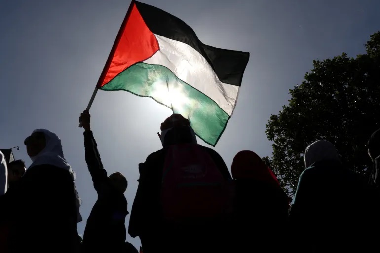 A person holds a Palestinian flag during the annual Quds Day (Jerusalem Day) in Cape Town, South Africa on April 14, 2023 [File: Reuters/Esa Alexander]