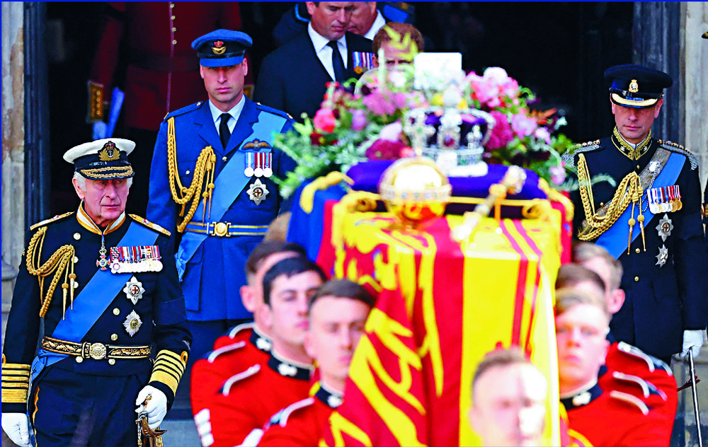 King Charles III, William, Prince of Wales, and Prince Edward walk as the flag-draped coffin of the queen is carried out of Westminster Abbey. REUTERS