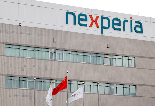 Flags fly next to a logo of Nexperia at the facade of its factory amidst a shortage of chip supply caused by a diplomatic standoff between China and Netherlands over the company, in Dongguan, Guangdong province, China, November 7, 2025. REUTERS/Maxim Shemetov/File Photo