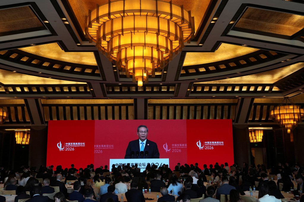 Chinese Premier Li Qiang is seen on a big screen live broadcasting his speech at the opening of the China Development Forum 2026 held at the Diaoyutai State Guesthouse in Beijing, China, March 22, 2026.  (Reuters)