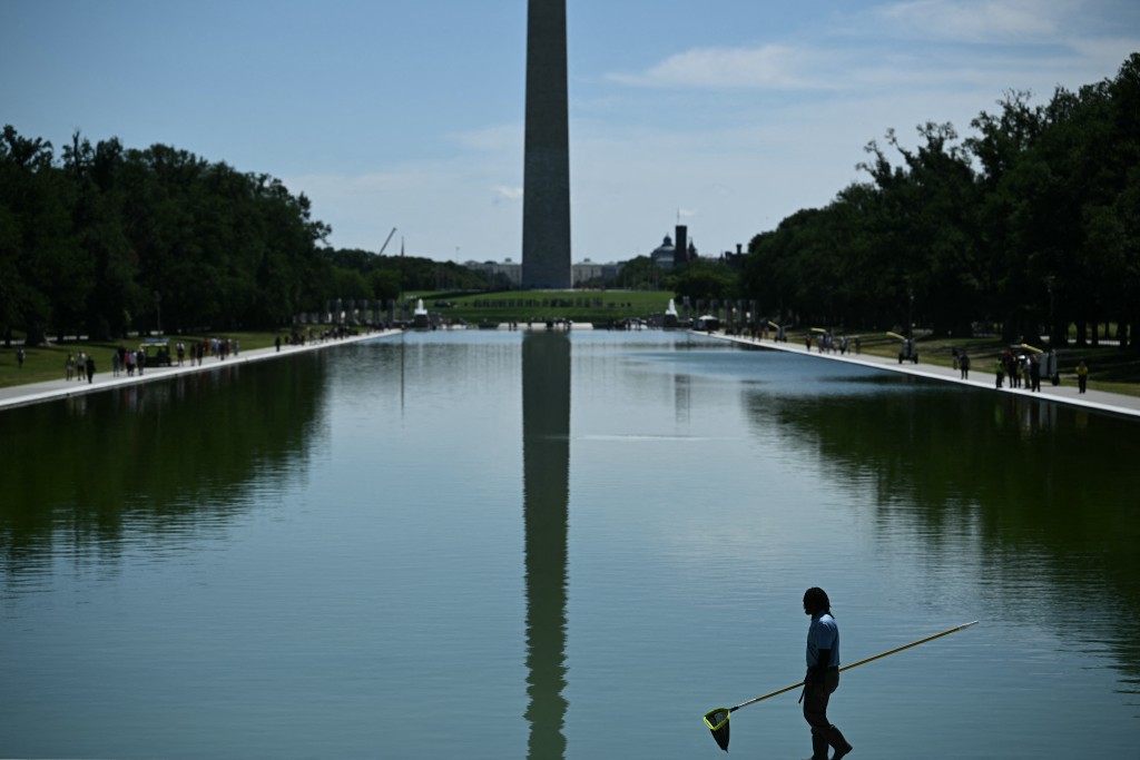 Photo by BRENDAN SMIALOWSKI / AFP  A worker removes algae from the Lincoln Memorial Reflecting Pool following the completion of recent renovations in Washington, DC, on June 16, 2026.