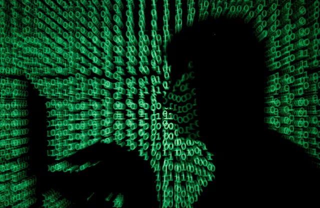 A man holds a laptop computer as cyber code is projected on him in this illustration picture taken on May 13, 2017. REUTERS/Kacper Pempel/Illustration/File Photo